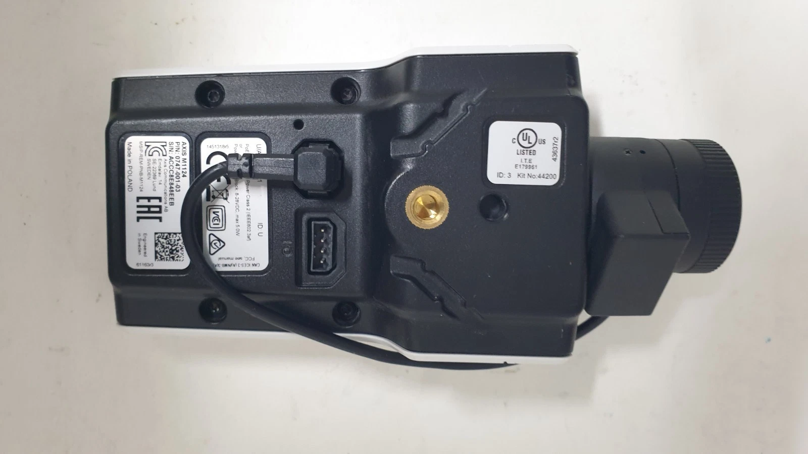 Rear of the AXIS M1124 camera with connector panel, product labels and brass tripod thread