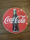 Vintage Coca-Cola round metal advertising sign featuring the classic Coke bottle