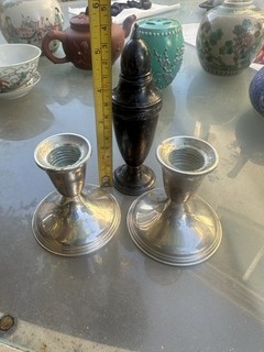 A pair of sterling silver candlesticks and a scent bottle