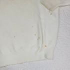 White Christian Dior men's V-neck sweater with visible yellow stains on fabric, made in USA.