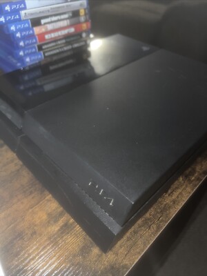 ps4 console, with 9 games shown and controller with HDMI and power cord