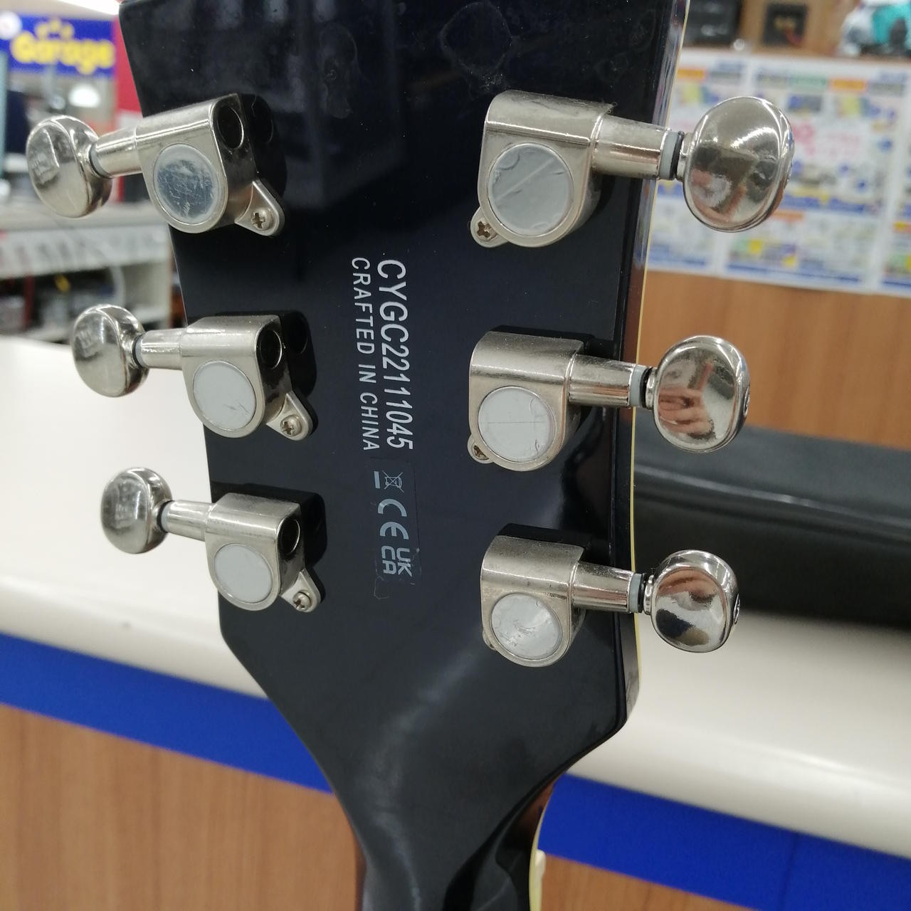 Black GRETSCH G5655T-QM hollow body electric guitar with silver hardware and six chrome tuning pots on the back.