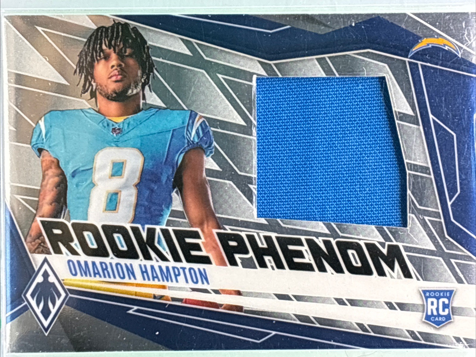 2025 Panini Phoenix - Rookie Phenom Jersey Omarion Hampton #PJY-OHN /699 (MEM)