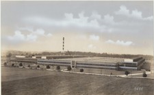 PHOTO OF FACTORY BUILDING WITH VINTAGE CARS PARKED OUTSIDE