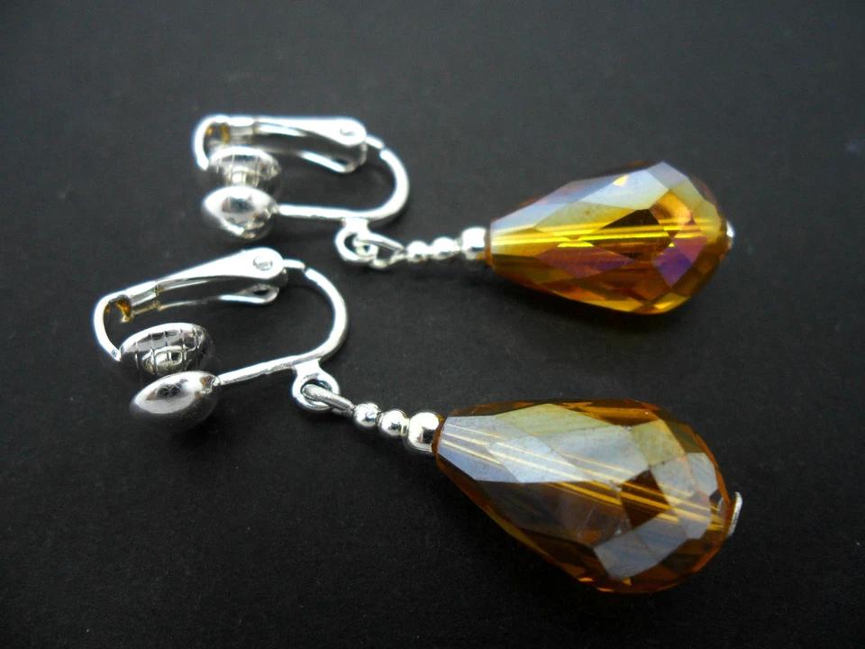 A PAIR OF SHORT AMBER GLASS CRYSTAL TEARDROP CLIP ON EARRINGS. NEW. - Image 1 of 1