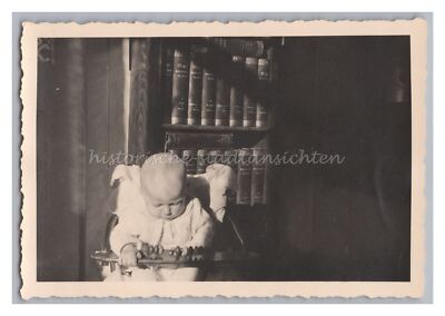 Child in Highchair in Front of Shelf Meyers Conversation Dictionary - Old Photo