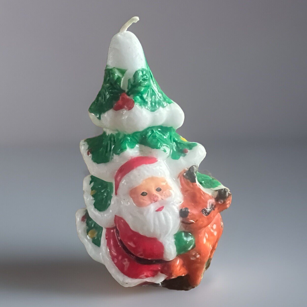 VGT CANDLE SANTA CLAUS HUGGING A REINDEER. STANDING IN FRONT OF A CHRISTMAS TREE
