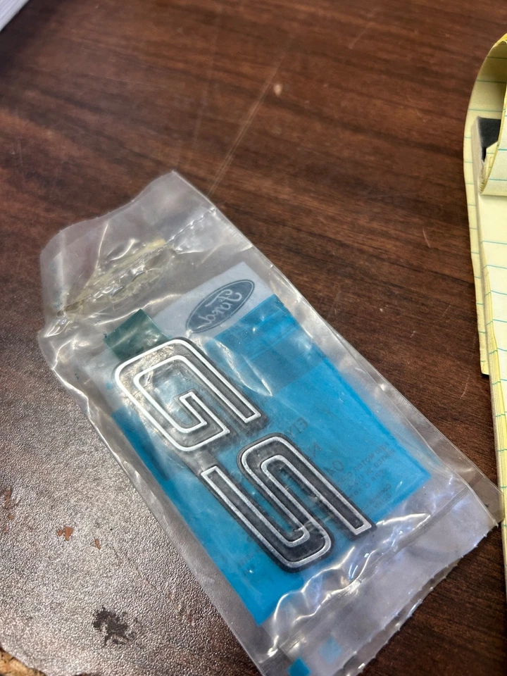 E1YY-16098-A ''GS'' 1981-1987 MERCURY LYNX ''GS'' FRONT FENDER NAMEPLATE NEW NOS Foto 2 de 3