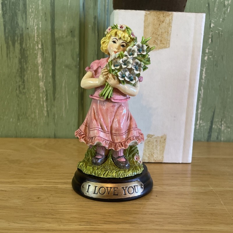 Noble Arts - Girl holding flowers on pedestal "I Love You"