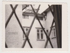 Through the Bars Glimpse of Quiet Courtyard Beyond Iron Lattice Abstract Photo
