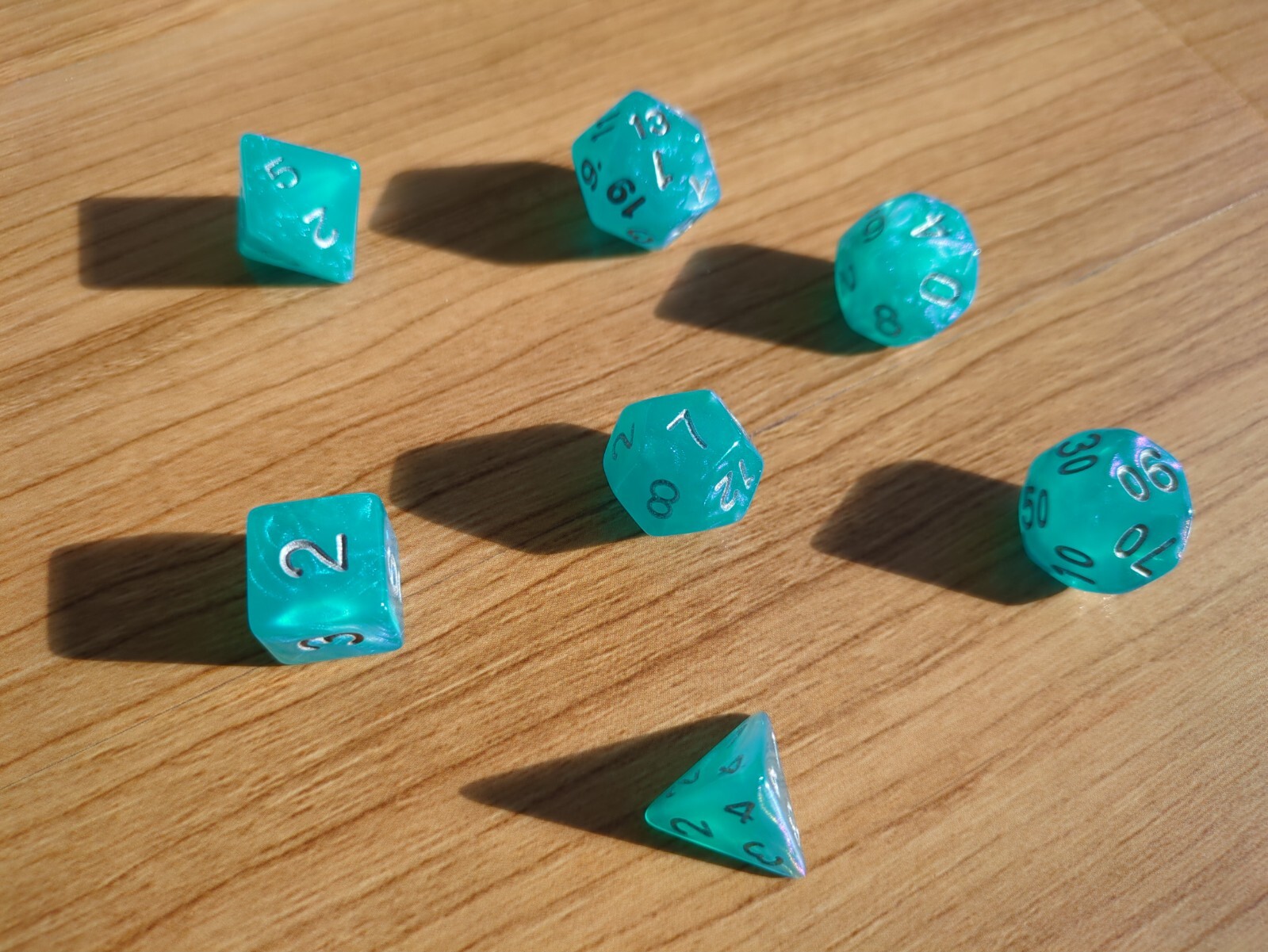 set of 7 dice, semi-transparent blue shimmer with silver numbers