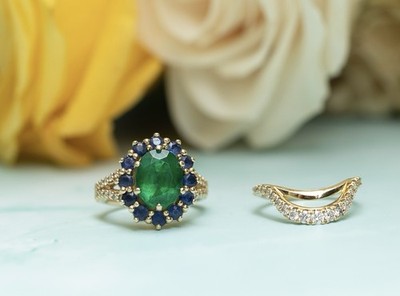 vintage-style oval emerald and sapphire halo engagement ring in 18k yellow gold