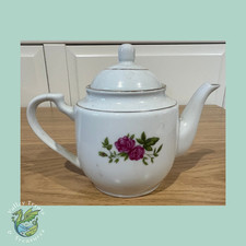 Vintage white porcelain teapot features a pink rose floral motif with gold trim