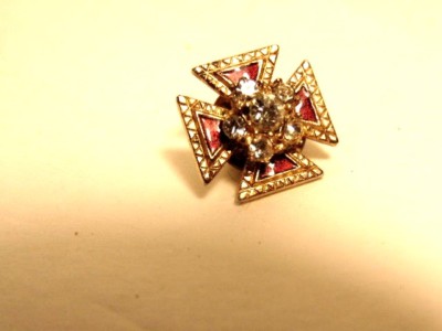 small gold colored cross shaped pin or tie tack w/ red enamel and