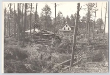 Black & White Photo Of Heavy Storm Damage Around Some House In The Woods