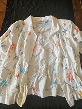 White blazer with quarter length sleeves and colorful embroidered flowers