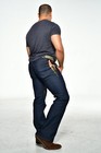 Man wearing dark denim B U jeans size 32x35 with bootcut legs, back pockets, and camouflage rear pocket design.
