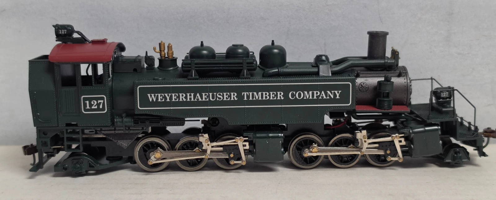 Weyerhaeuser 2-6-6-2 articulated steam flywheel drive in green and red livery with “127” lettering on tender side.