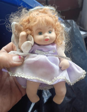Baby Doll Girl with Blonde Curly Hair, Light Complexion, Purple Dress