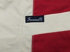 White fabric label with blue “Faconnable” text, red and blue diagonal stripes, and stitched seam detail.