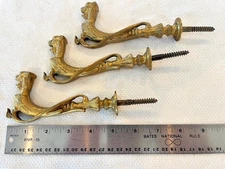 An antique set of three gilt bronze lion hooks