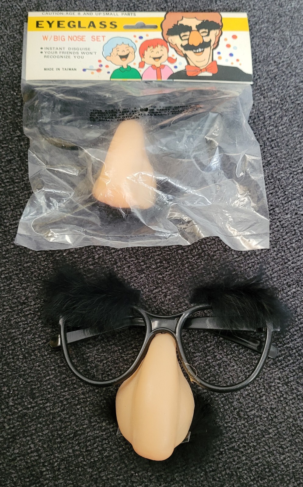American Novelty Comedy Eyeglass Big Nose Set with black and white glasses, packaged in clear plastic with red and yellow label.