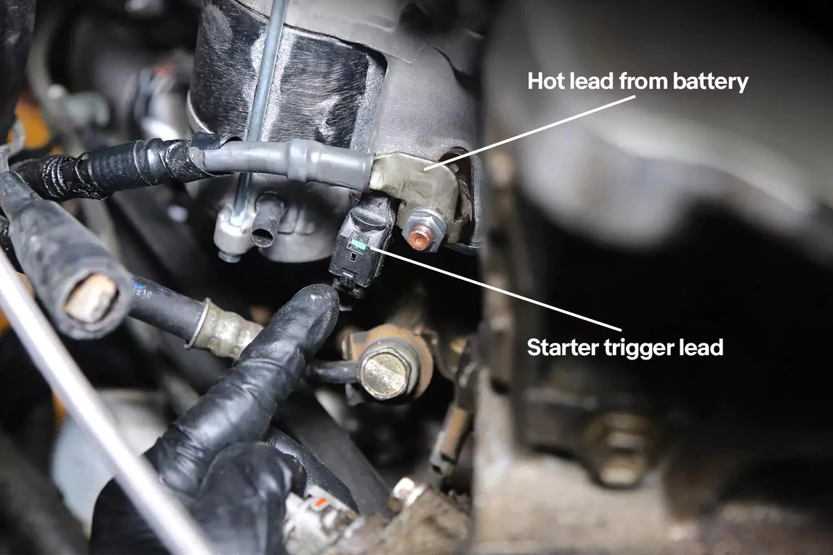 A close-up view of a bump starter's trigger lead attached to the hot lead from a battery.