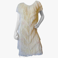 This garment is a vintage cream-colored, short-sleeved tiered fringe dress that