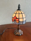 Tiffany-style table lamp featuring stained glass shade with red  & pink Flower