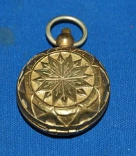 An antique brass sovereign case, star cut design, textured coin chamber