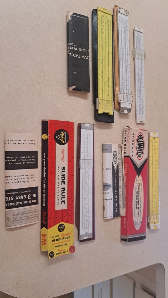 A lot of 5 genuine vintage Pickett & Acumath slide rules — analog computing history you can hold in your hands, and a visually striking desk display.