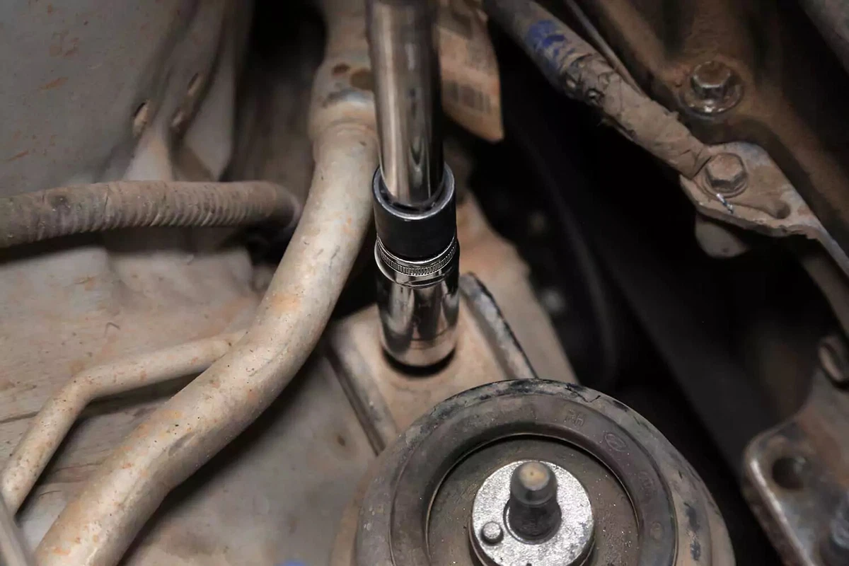 Socket wrench removing the bolt that secures the motor mount to the chassis.