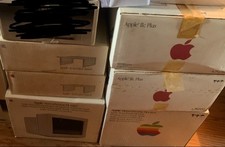 An unopened vintage Apple 2c Plus computer, with monochrome Monitor and stand