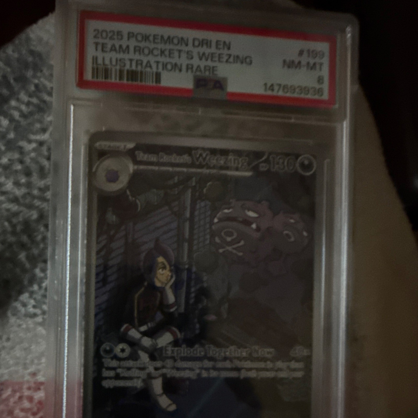 PSA 8 2025 Pokémon Team Rocket’s Weezing Illustration Rare holo card with silver-toned figure art in protective case.