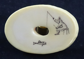 Howard Weyahok's scrimshaw art on a slice of material Fishing Theme