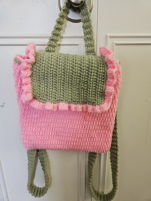Handmade Crochet backpack is crafted with soft yarn in a sweet pink and green