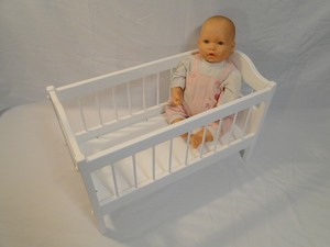 white wooden doll crib