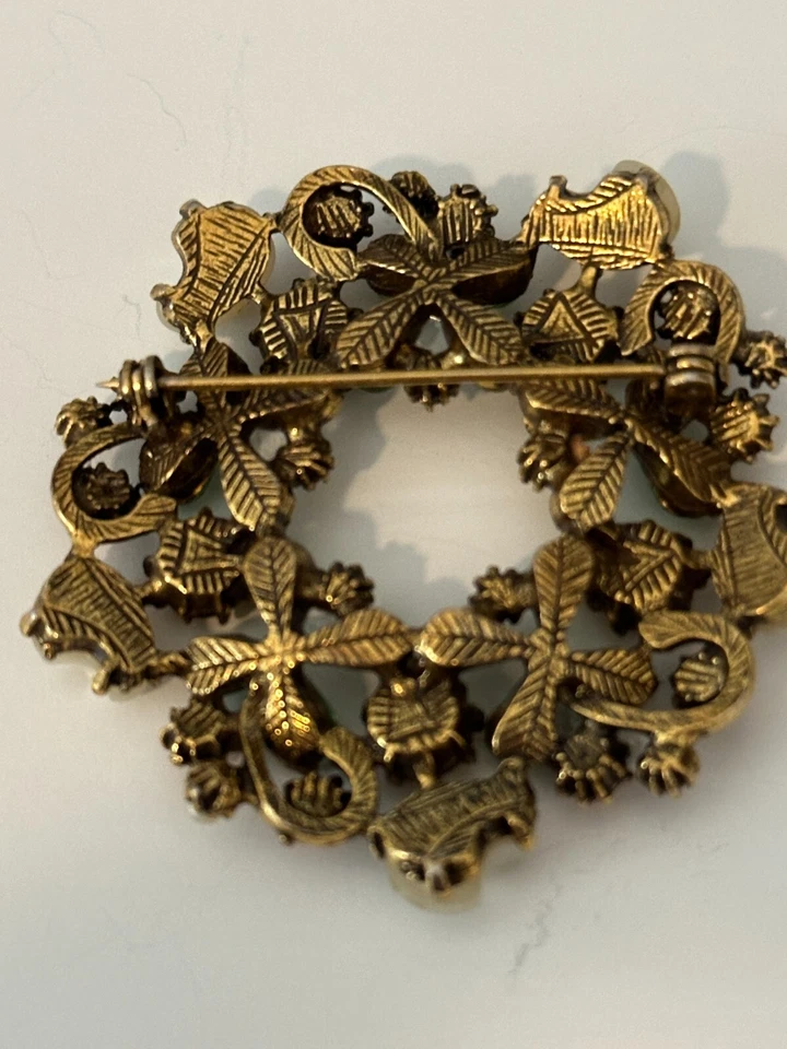 Hermoso broche redondo verde claro y naranja con detalles de perlas Foto 3 de 3