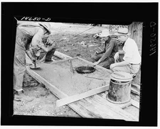 Photo:Placing concrete in form for privy slab. Minnesota