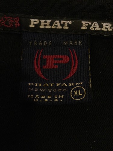 White fabric tag on black shirt with red “PHAT FARM” text, red and black logo, and “Made in U.S.A.” label.
