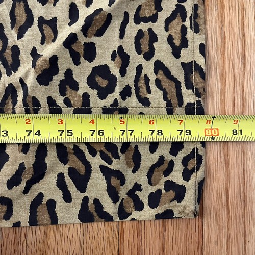 Brown and black leopard print cotton sheet with yellow measuring tape showing dimensions.