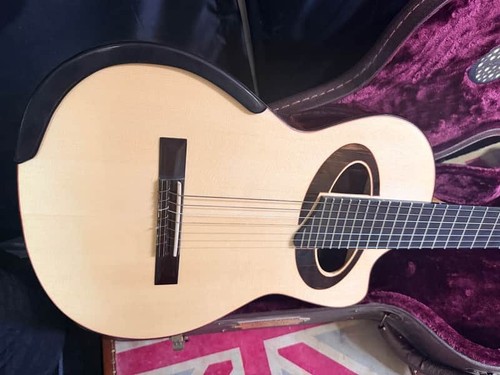 Light wood Laviolette 7-string classical acoustic electric guitar with black fretboard, silver hardware, and padded dark brown case.