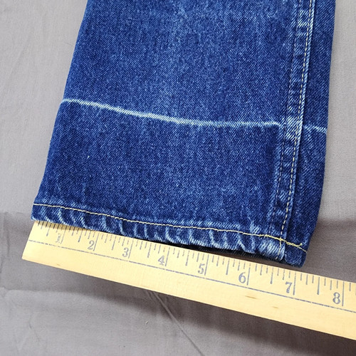 Blue denim high-rise straight leg with white contrast stitching, yellow measuring tape across the bottom.