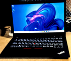 Black Lenovo ThinkPad P14S Gen 2 with touchscreen displaying colorful abstract background and red keyboard text.