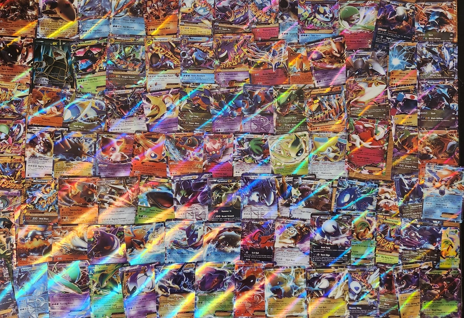 A large pile of holographic Pokemon cards