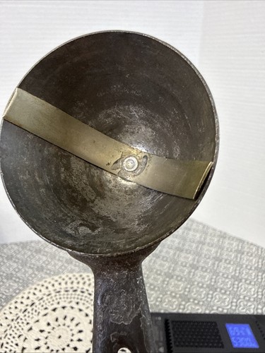 Worn silver metal ice cream scoop with visible scratches and textured surface, made in USA around 1900.