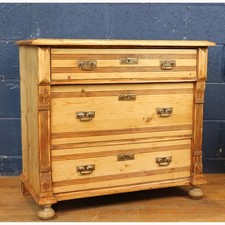 A Victorian Carved and Waxed Pine Graduated Chest of Three Drawers