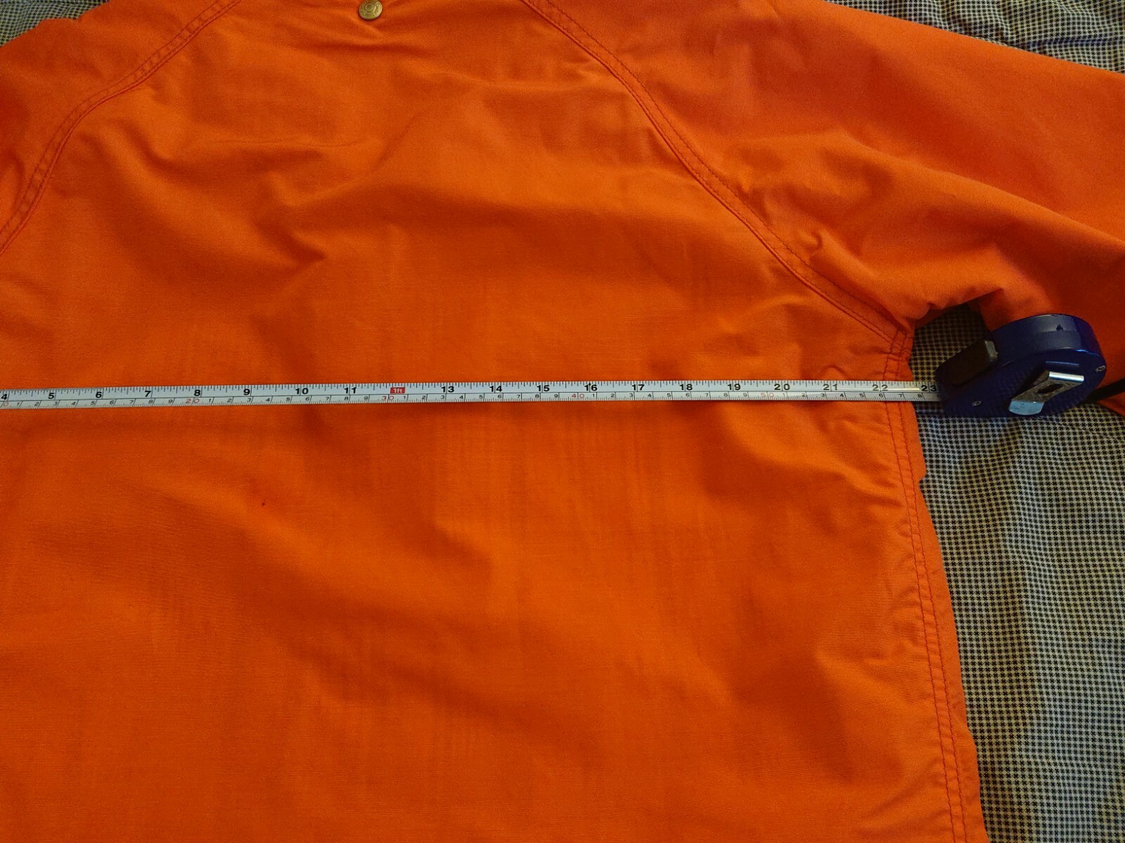 Orange cotton-nylon 70s-style parka with button front, flap pockets, and measured length across the chest.