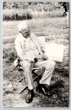 RPPC Very Old Man Seated in Yard Showing off Paper Postcard D21