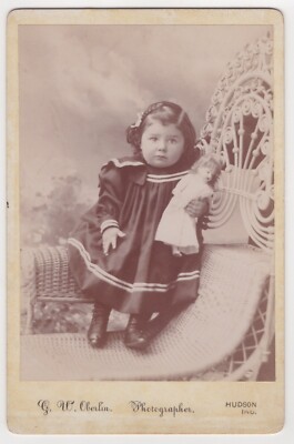SWEET LITTLE GIRL HOLDING HER DOLL :WICKER CHAIR: HUDSON, INDIANA : CABINET CARD